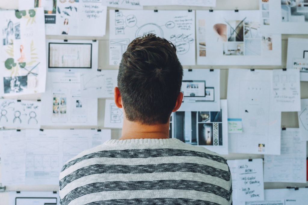 man looking at strategy pinned on the wall