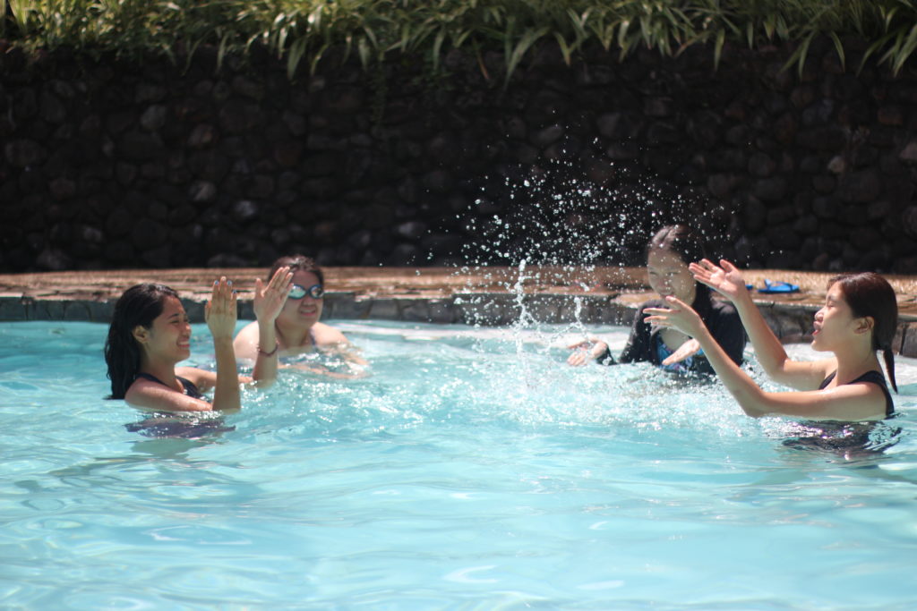 female team members having fun in the pool