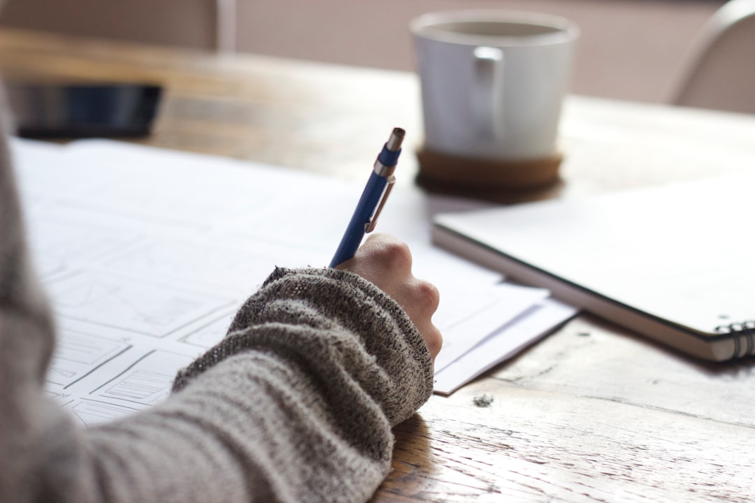 Growth Rocket person writing on brown wooden table near white ceramic mug